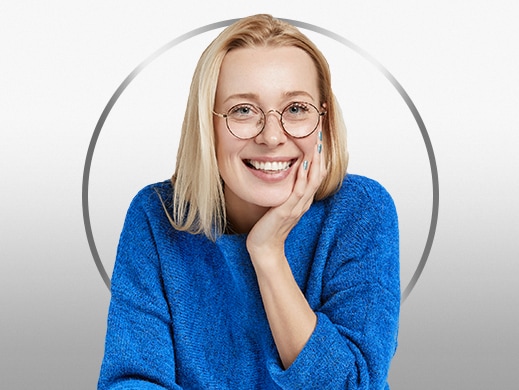 Lächelnde, blonde junge Frau im blauen Sweater